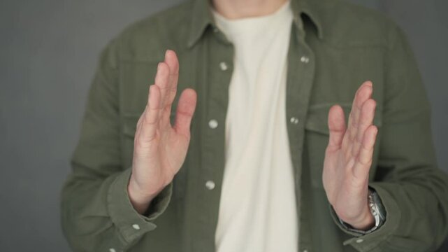 The man shows the size with his hands.
Hand gesture showing size.
Long, short, narrow, wide, centimeters