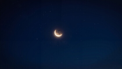 Crescent moon glowing in night sky with scattered stars, celestial beauty