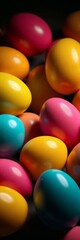 Colorful easter eggs in a variety of bright hues on a dark background