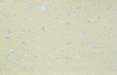 Light yellow decorative flakes wall texture or pattern as background