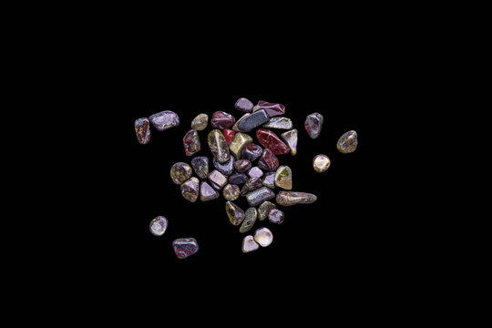 gravel chips Polished stack of blood dragon jasper isolated on black background top view