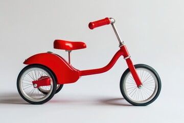 Obraz premium Vibrant Red Tricycle Against a Pure White Background - A Nostalgic Toy for Childhood Adventures