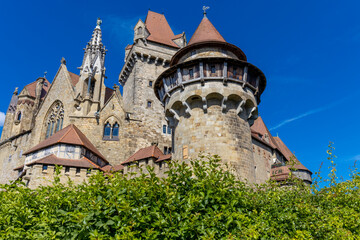 Fototapeta premium Ancient castles architecture in Europe. Austria medieval citadel made of bricks. Rocky walls of an old historical castle with towers and bridge on a sunny summer day, European landmark and history
