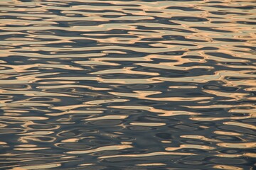 The water surface of the river at sunset. The effect of moire silk. Background