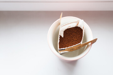 Drip bag in a ceramic cup on windowsill. Instant freshly brewed alternative filter drink in mug. Easy brew black coffee method for home, travel or office. cozy trendy lifestyle 