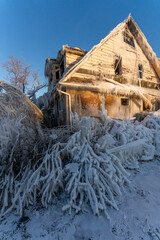 Abandoned house covered in ice after winter storm