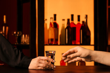 Women with shot of cold vodka on table in bar