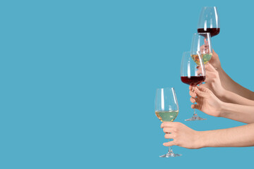 Women with glasses of wine on blue background. Valentine's Day celebration