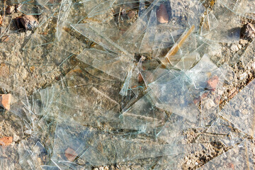 Glass shards scattered across a rough concrete surface
