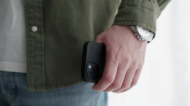 A man is holding a phone in his hands.
A man in a green shirt and with a phone in his hands.
A man is burning someone.
A person with a smartphone.
Smartphone close-up