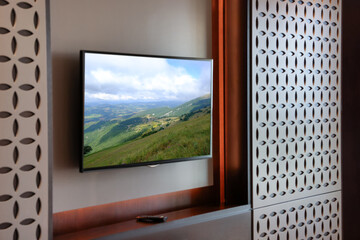 Fototapeta premium TV set with mountain landscape on screen in room