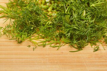 A close-up shot of chopped dill on a wooden cutting board, highlighting its texture and freshness