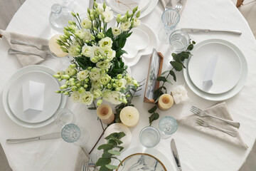 Beautiful table setting with eustoma flowers and candles for wedding celebration in room, top view