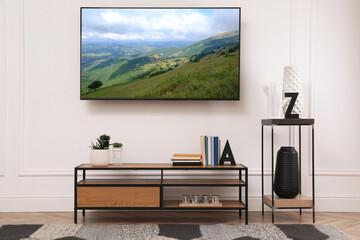 TV set with mountain landscape on screen in room
