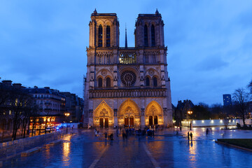 Obraz premium Beautiful cityscape view of the Notre-Dame Cathedral in Paris, France, on a rainy spring evening with reflection in the blue hour