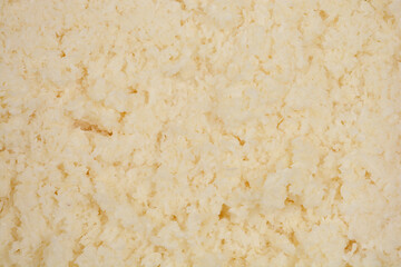A close-up, textured view of unbaked batter made from beaten egg whites and coconut, showing its...