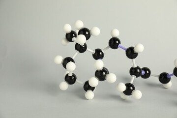 Molecule of retinol (vitamin A) on light grey background, closeup. Chemical model