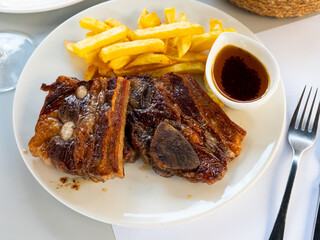 Churrasco de ternera, appetizing grilled veal spare ribs with garnish of french fries