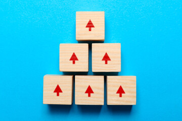 Wooden cubes with red arrows on light blue background, top view