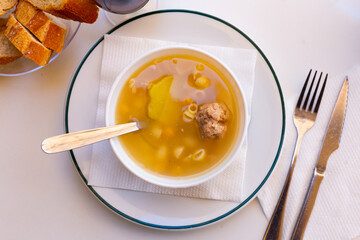 Appetizing hearty soup with meatballs, pasta, vegetables and chickpeas. Traditional Christmas Catalan dish