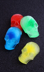 Different colored ice in the shape of a human skull on a black background
