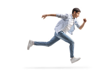 Full length profile shot of a young man in jeans running fast