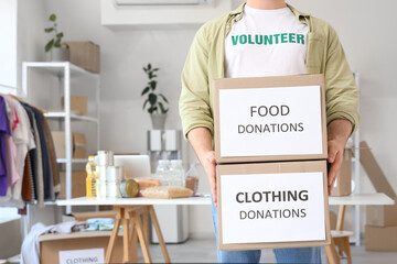 Male volunteer with donation boxes in center, closeup