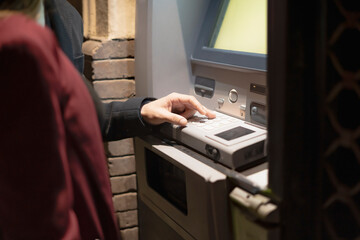 Businessman withdrawing money at atm at night