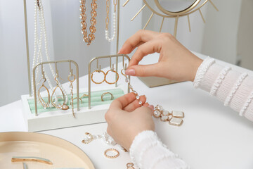 Young woman with organizer of stylish different jewelry near table
