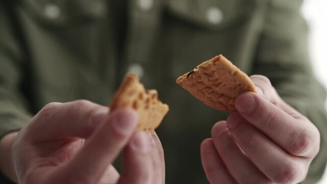 Crispy cookies close-up.
Man eating cookies close-up.
A man eats crackers in front of the camera.
A man eats delicious crackers.
Appetizing cookies in the hands of a man