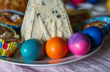Traditional easter table with colorful vibrant dyed eggs, easter bread and Pashka - Russian orthodox festive quark dessert, representing spring holiday celebration, family traditions, and cultural cui