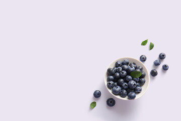 Bowl with fresh ripe blueberry on light background
