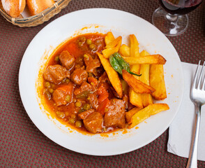 Appetizing beef stew served with stewed vegetables and potatoes on platter