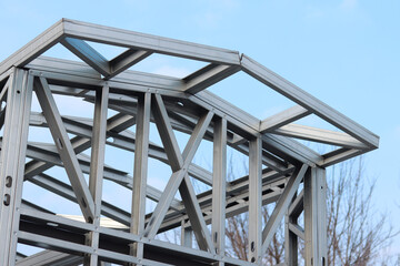 Obraz premium Lightweight steel thin-walled structures. Frames for warehouses, garages or houses. Structure of a steel frame for construction against the sky