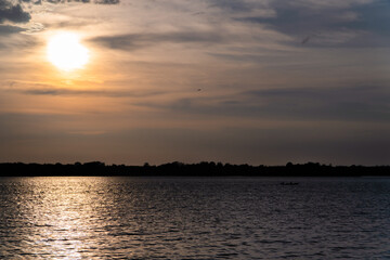 Naklejka premium sunset in South America with the sun giving a golden touch to the water. Landscape in Colombia