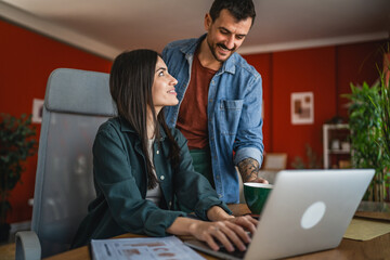 Fototapeta premium husband support and help to his wife while she work from home on laptop