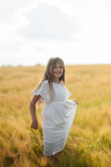 A beautiful girl is picking flowers in the forest on a glade.
