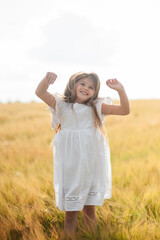Child girl running through field of wheat, sunset.