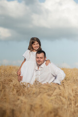 dad and daughter hug in a wheat field.Cute beautiful children.