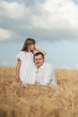 dad and daughter hug in a wheat field.Cute beautiful children.