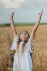 A very beautiful little girl.The child is smiling.Wheat field sunny day.