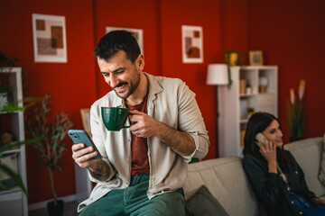 relax man sit and use mobile phone and drink coffee at home