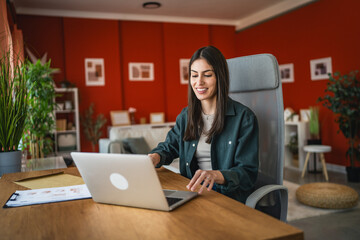 Fototapeta premium Adult caucasian woman work on laptop and use notebook from home office