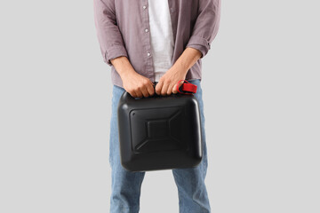 Young man with canister on grey background