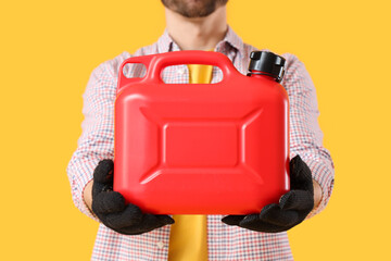 Young man with canister on yellow background, closeup