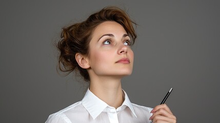 Obraz premium Woman Thinking, Looking Up, Holding Pen, Studio Portrait, Potential for Business or Motivation