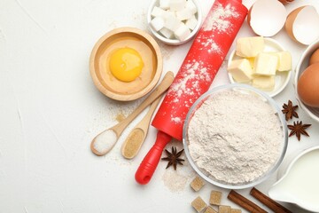 Rolling pin and different ingredients on white table, flat lay