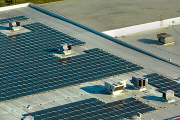 Photovoltaic solar panels mounted on industrial building roof for producing green ecological...