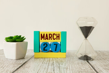 27 March calendar on wooden table with customizable space.