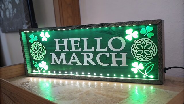 bright green "Hello March" sign with festive decorations, clover leaves, and glowing lights